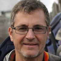 A smiling man with graying hair and glasses.