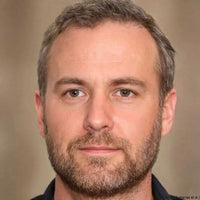 A man with a neatly trimmed beard and short, salt-and-pepper hair.